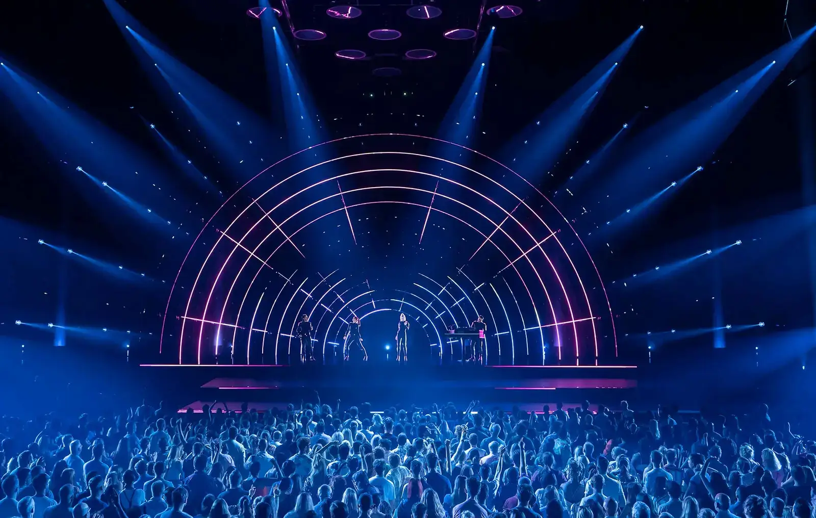 The band perform inside a glowing arch of light above the crowd