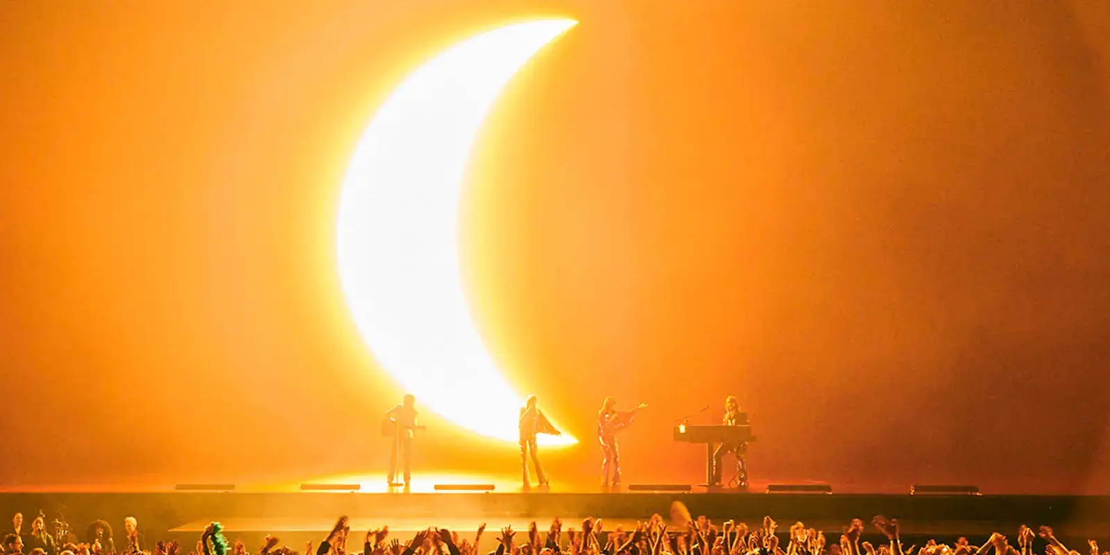The show before a giant golden crescent-moon screen