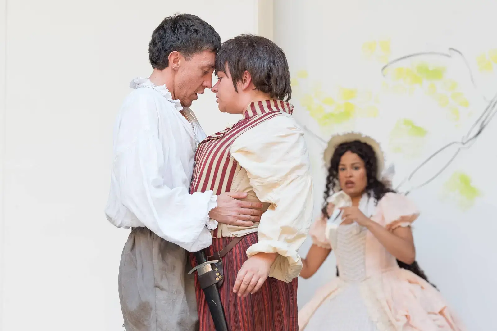 Orlando and Rosalind embrace as Celia looks on