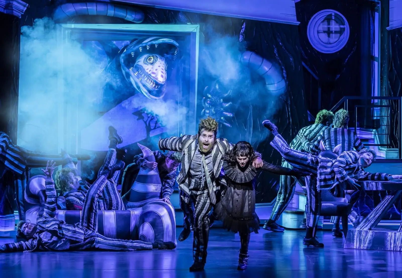 Beetlejuice and Lydia Deetz lead the company beneath the sandworm in Beetlejuice The Musical at the Prince Edward Theatre - photography by Johan Persson