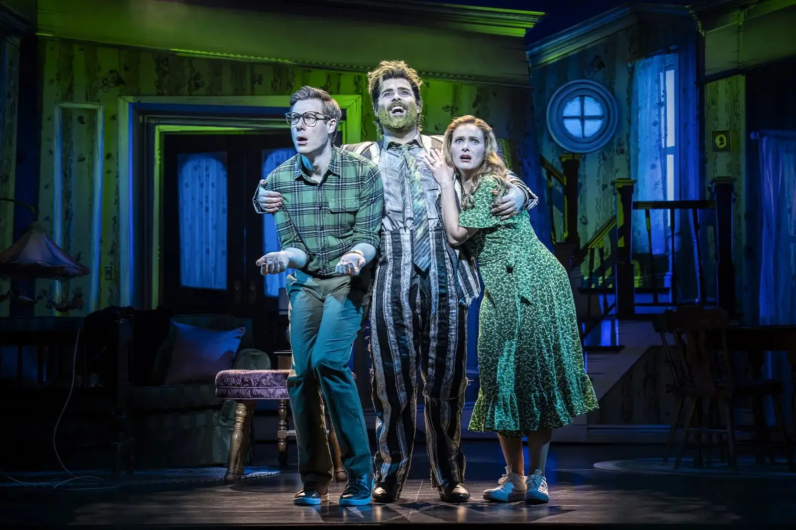 Adam and Barbara Maitland either side of Beetlejuice in their haunted house in Beetlejuice The Musical at the Prince Edward Theatre - photography by Johan Persson