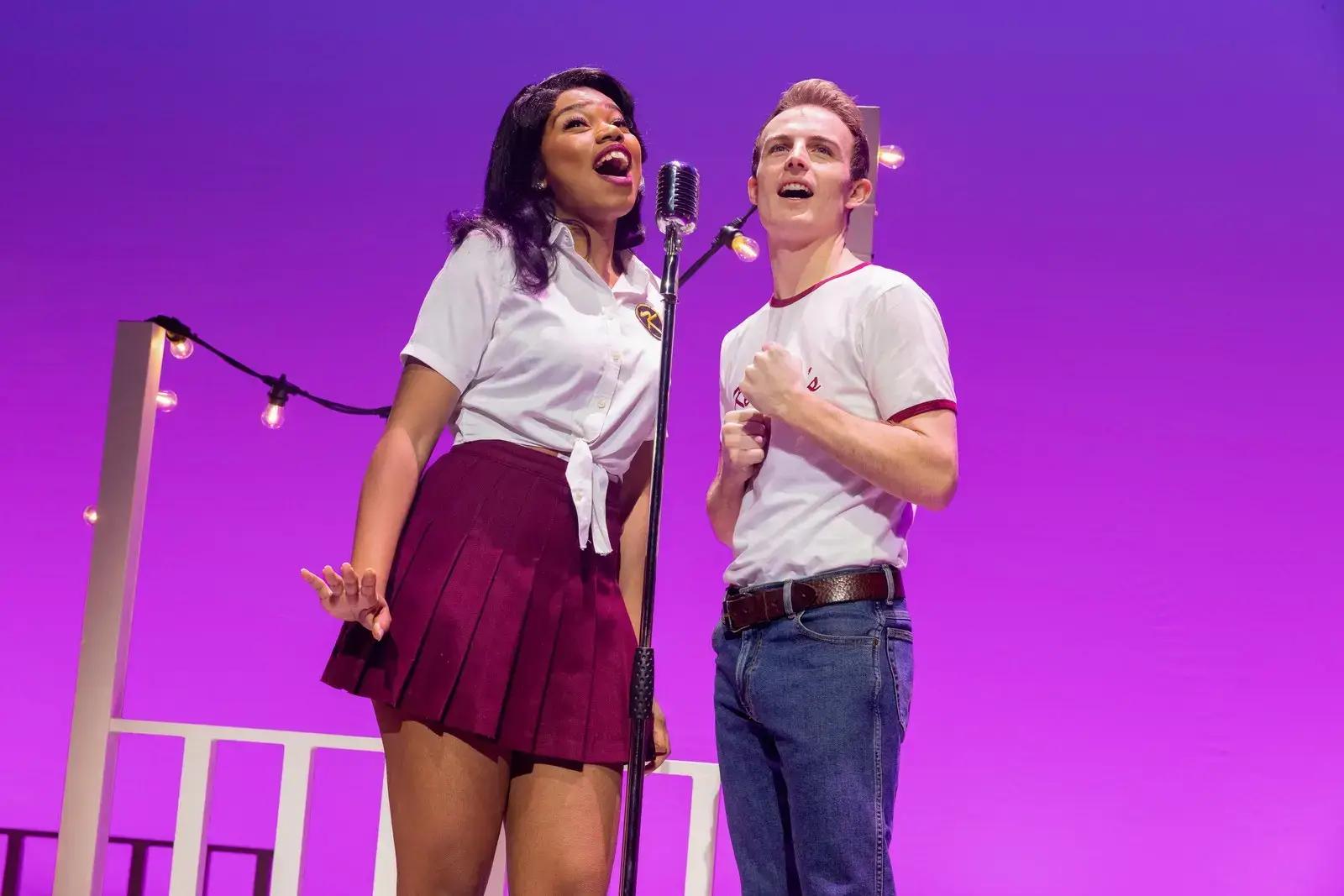 Two performers duet at a vintage standing microphone