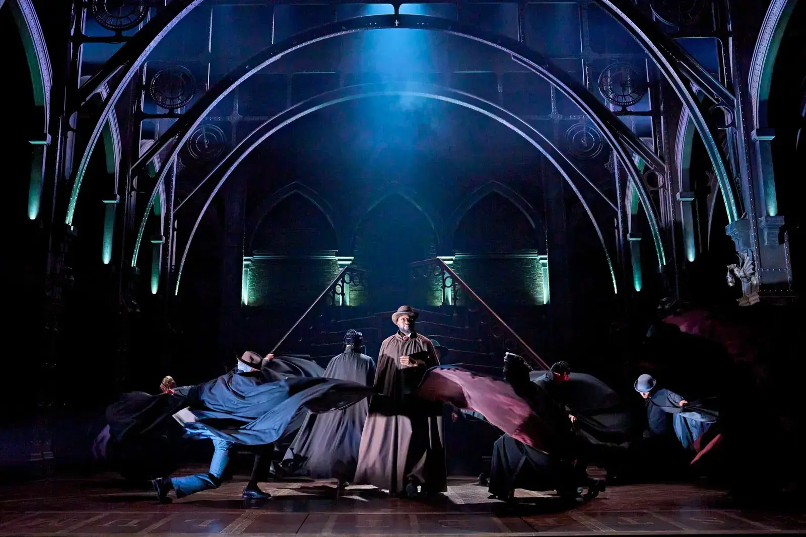 Cloaked figures swirl their capes on the great staircase set