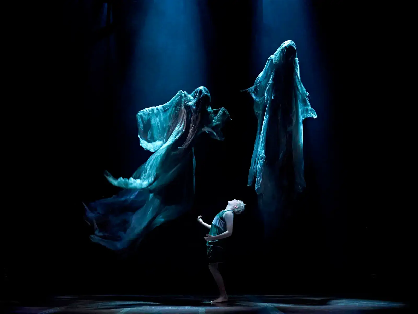 A boy recoils beneath two towering Dementors in cold blue light