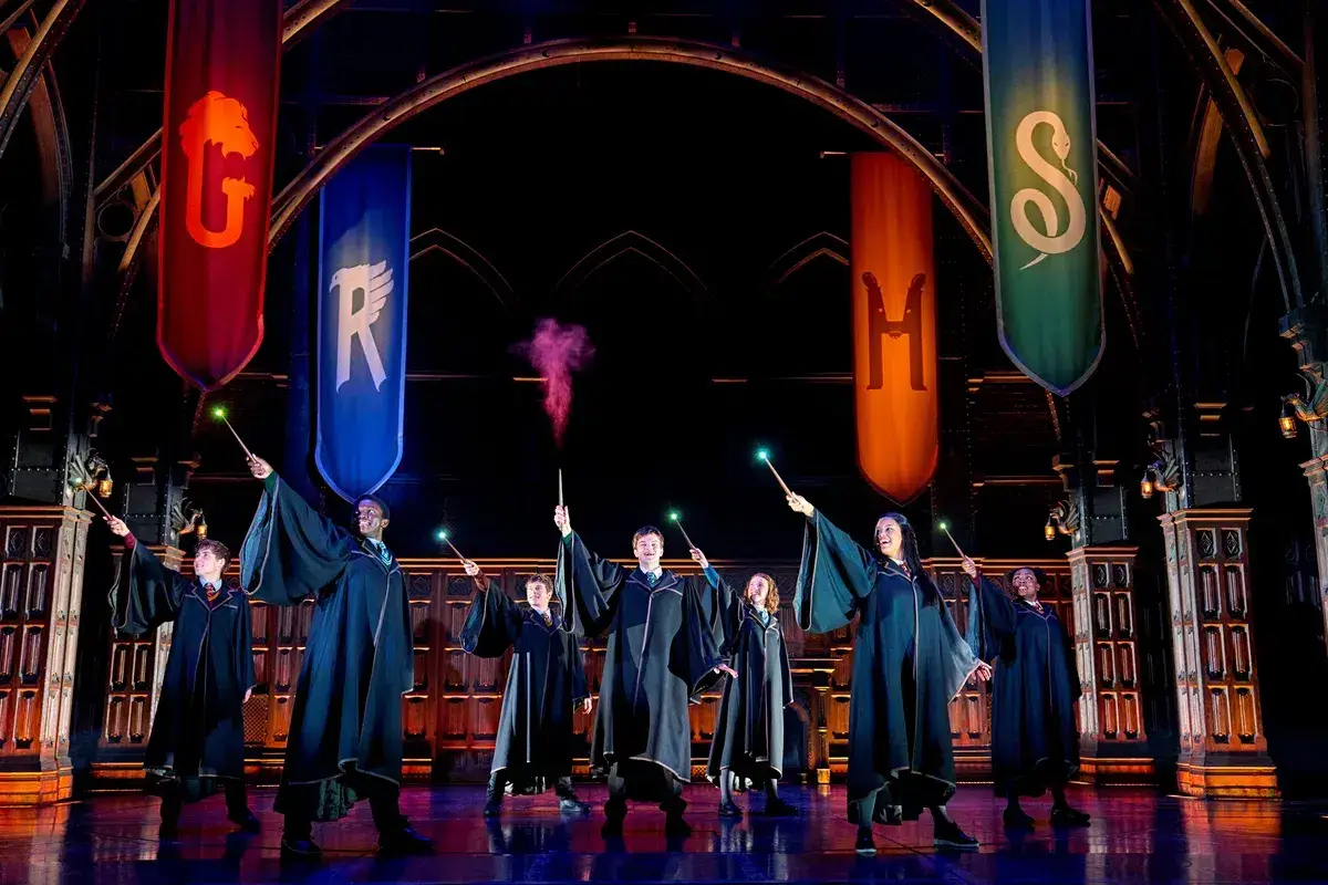 The cast beneath the Hogwarts house banners