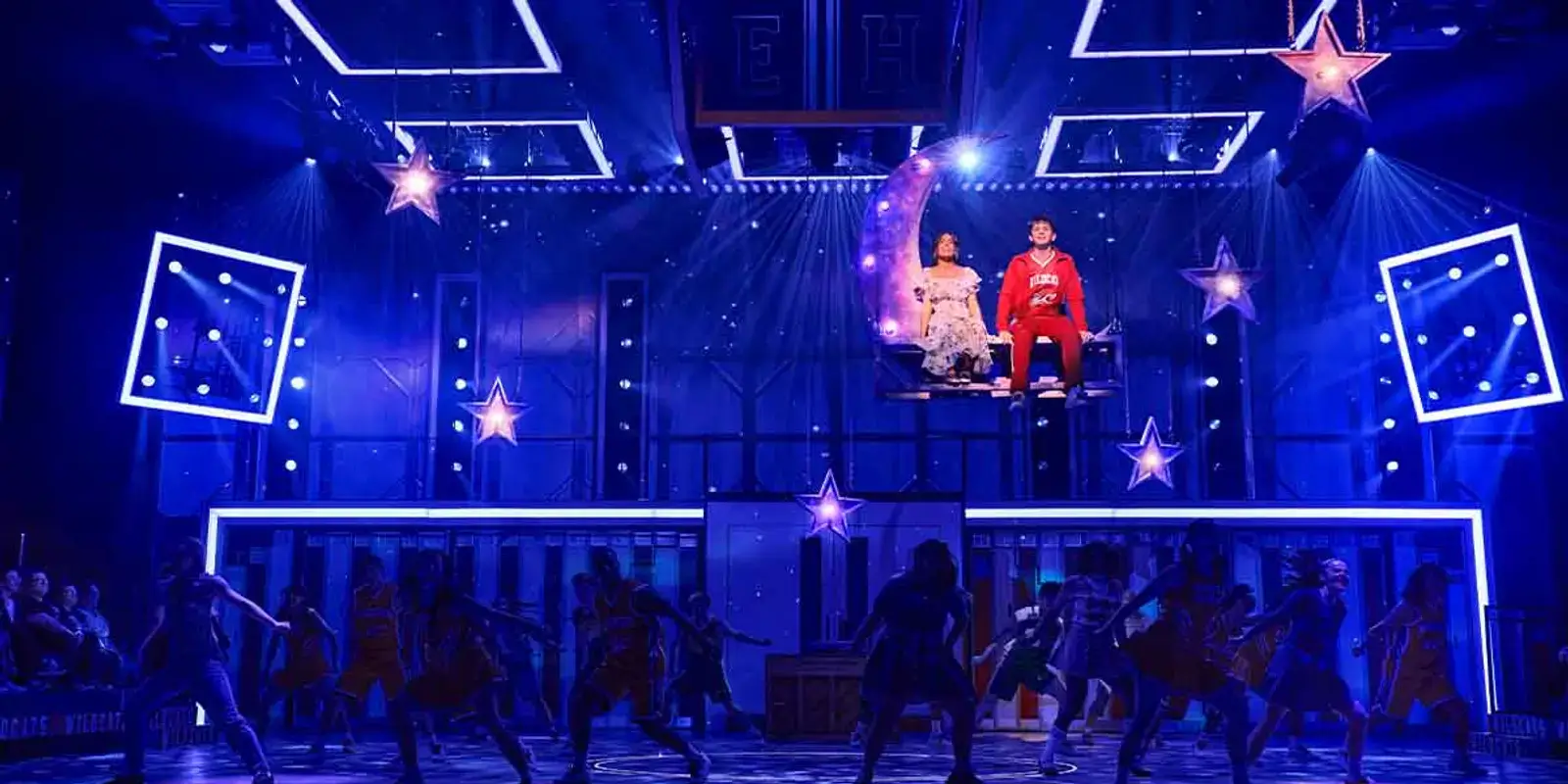 Gabriella and Troy on a crescent-moon rig above the company