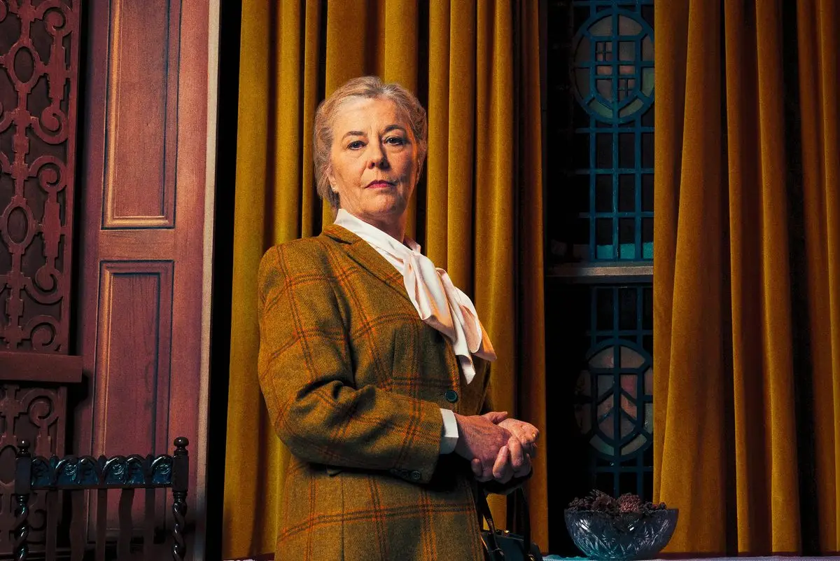 Mrs Boyle in front of the gold curtains in The Mousetrap at St Martin's Theatre, London