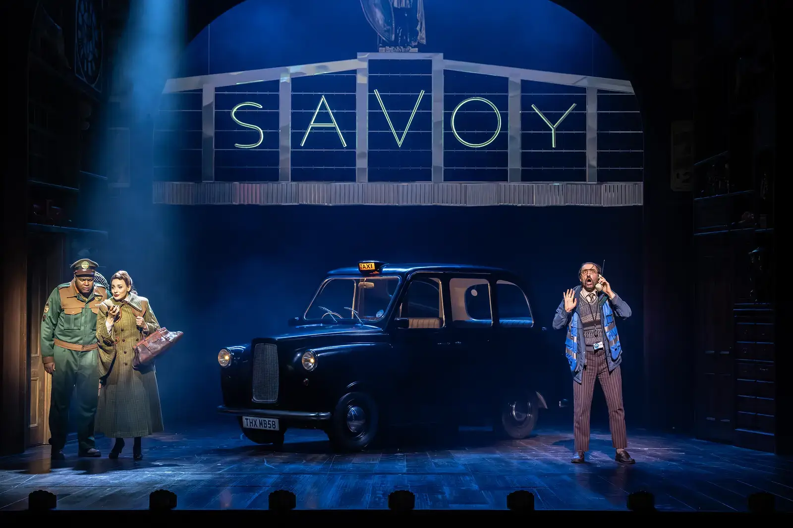 The illuminated Savoy sign and a London taxi on stage