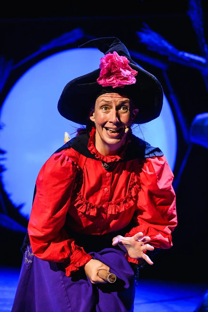 The Witch flies through the sky on her broom