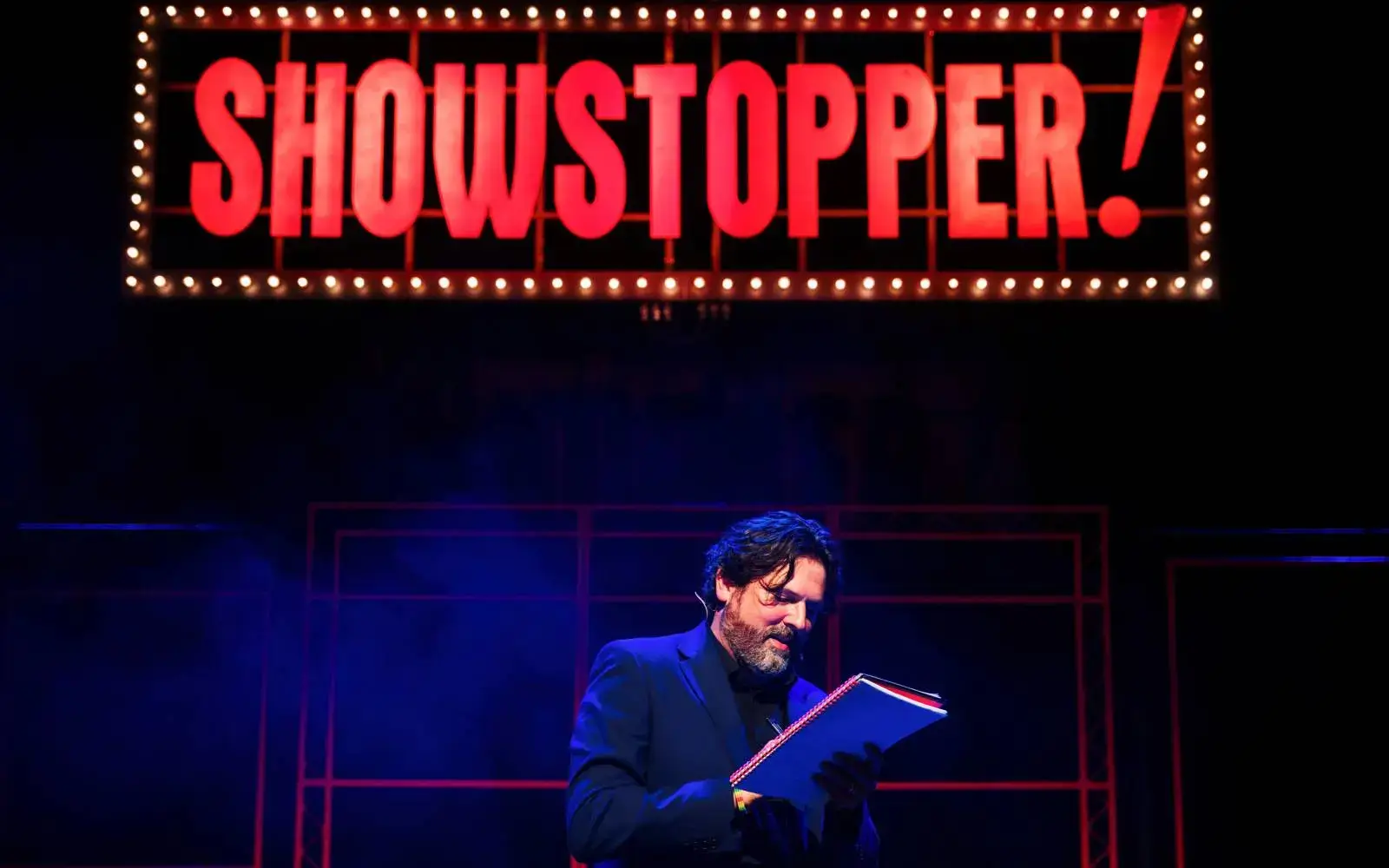 The host reads audience suggestions beneath the marquee