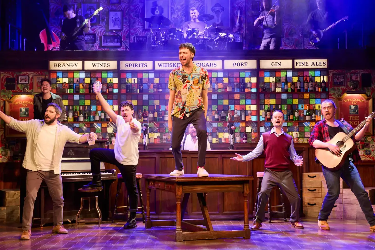 A soloist on a pub table, the company cheering him on