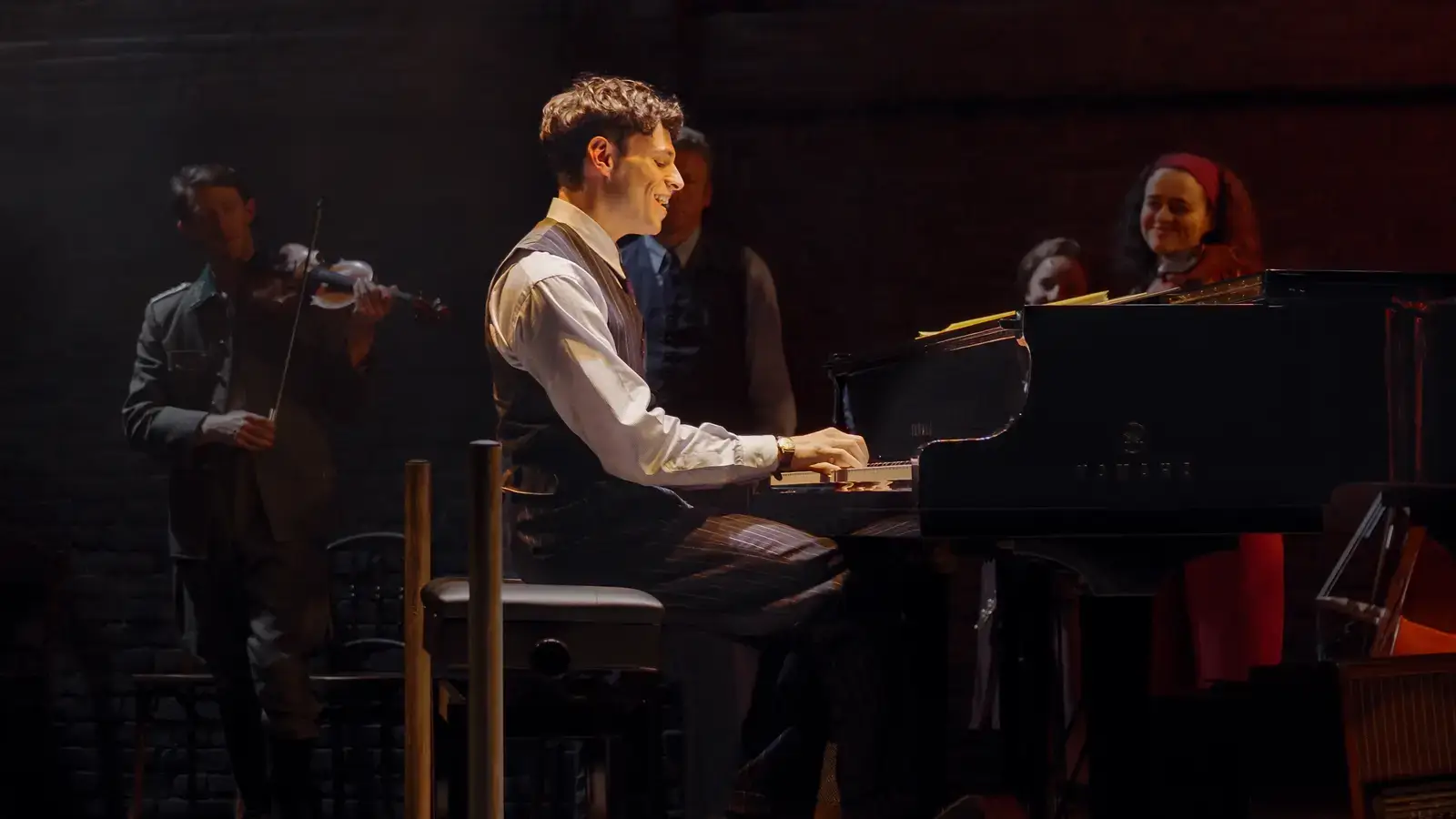 Wladyslaw Szpilman at the grand piano, surrounded by the company