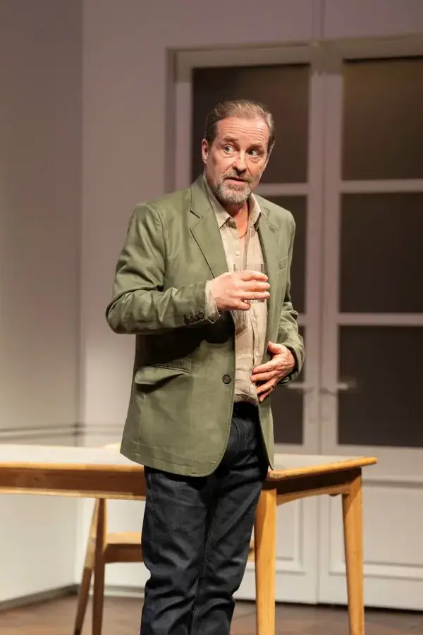 A man with a drink in a scene from The Truth at the Apollo Theatre