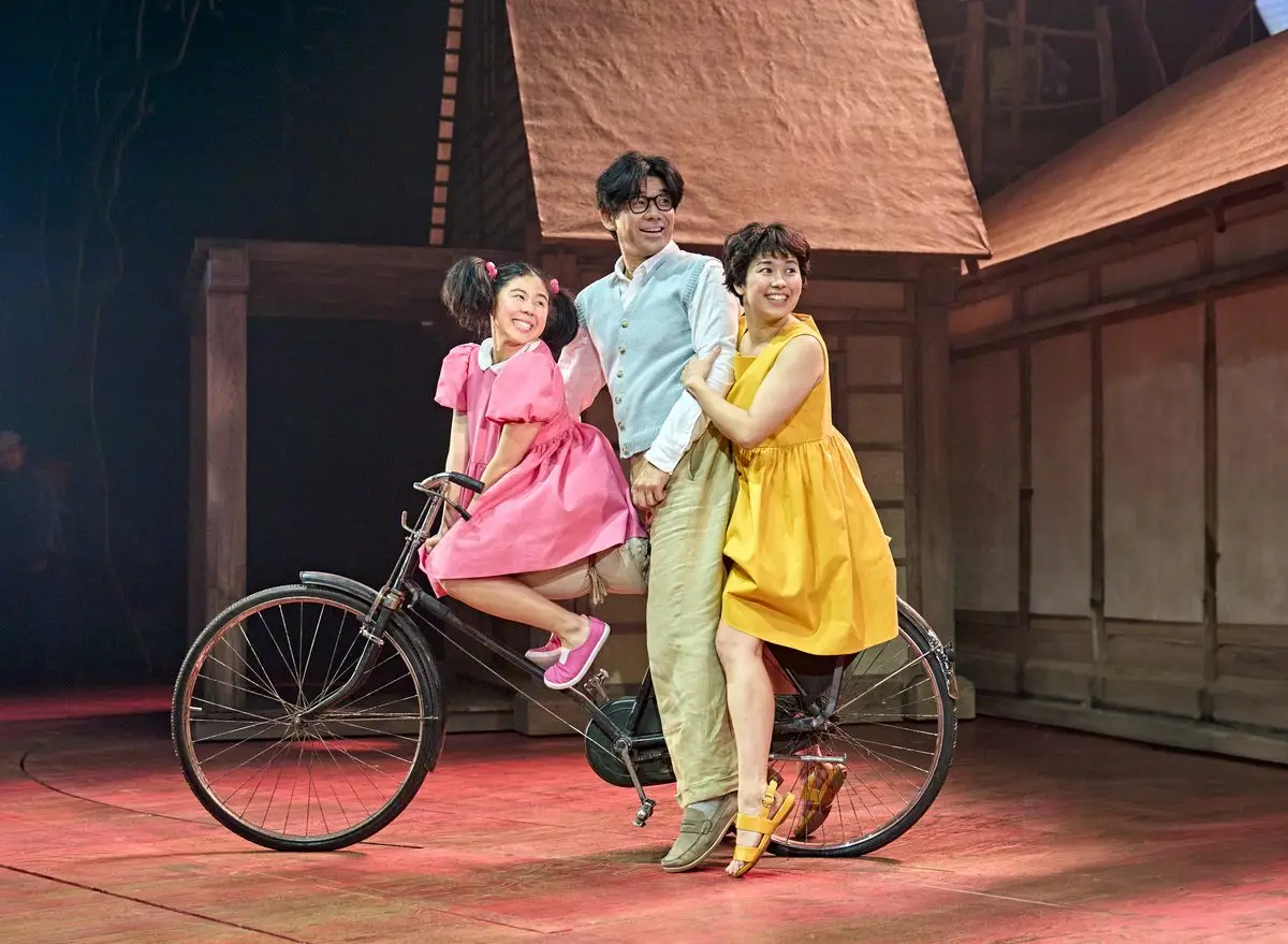 Mei, her father and Satsuki on the bicycle in My Neighbour Totoro at the Gillian Lynne Theatre, London
