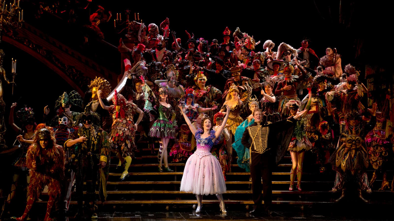 The Masquerade ensemble on the grand staircase in The Phantom of the Opera